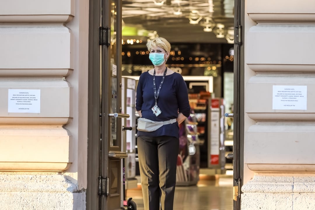 Woman wearing a mask in front of store