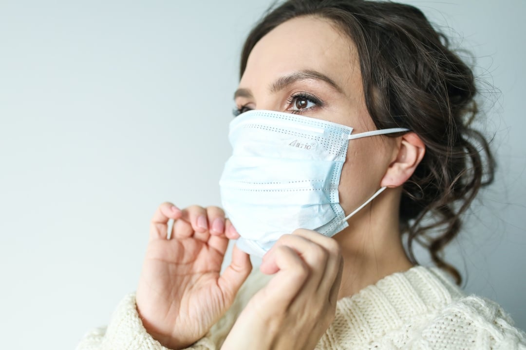 Woman putting on mask properly