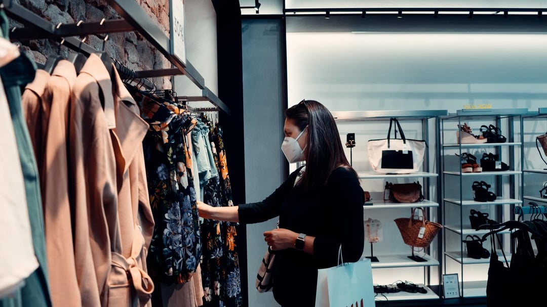 Shopping in a retail clothing store with a face mask on 